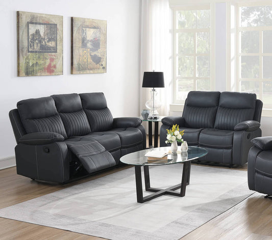 Dark Grey leather reclining sofa set in a living room with a glass coffee table and decorative items.